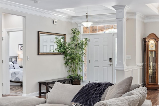 entryway featuring dark wood finished floors, crown molding, and decorative columns