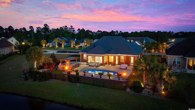 back of property at dusk featuring an outdoor living space with a fire pit