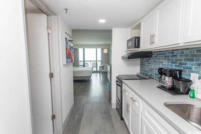 2401 S Ocean Blvd S Unit 1064, Myrtle Beach, SC 29577 - kitchen featuring electric range, black microwave, light countertops, decorative backsplash, and wood finished floors