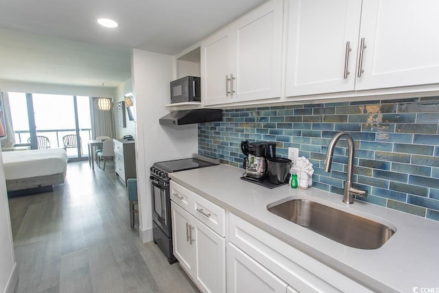 2401 S Ocean Blvd S Unit 1064, Myrtle Beach, SC 29577 - kitchen with black appliances, a sink, light countertops, white cabinetry, and decorative backsplash