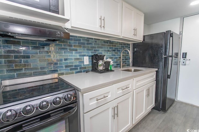 2401 S Ocean Blvd S Unit 1064, Myrtle Beach, SC 29577 - kitchen with black appliances, a sink, light wood-style flooring, and white cabinetry