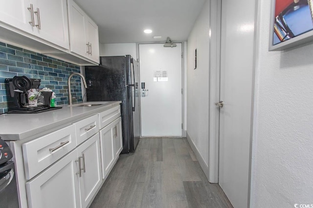 2401 S Ocean Blvd S Unit 1064, Myrtle Beach, SC 29577 - kitchen with a sink, wood finished floors, backsplash, light countertops, and white cabinets