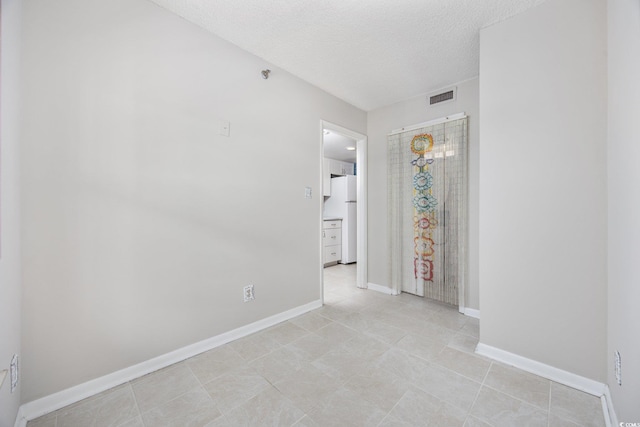 4000 N Ocean Blvd Unit 1002, North Myrtle Beach, SC 29582 - unfurnished room featuring a textured ceiling, baseboards, and light tile patterned flooring