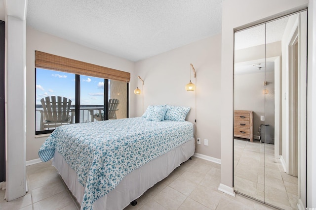 4000 N Ocean Blvd Unit 1002, North Myrtle Beach, SC 29582 - bedroom featuring light tile patterned flooring, a textured ceiling, baseboards, and access to outside