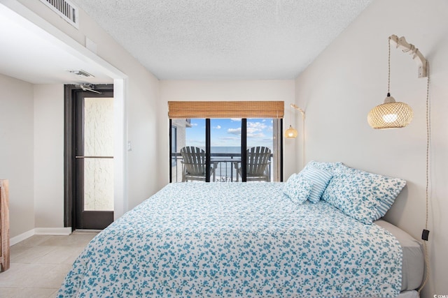 4000 N Ocean Blvd Unit 1002, North Myrtle Beach, SC 29582 - tiled bedroom with access to exterior, a textured ceiling, and baseboards