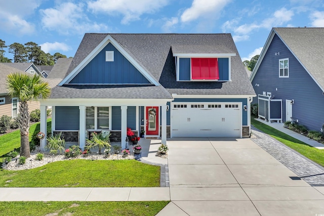 1012 Mary Read Dr, North Myrtle Beach, SC 29582 - view of front of home with board and batten siding, covered porch, concrete driveway, roof with shingles, and a front lawn