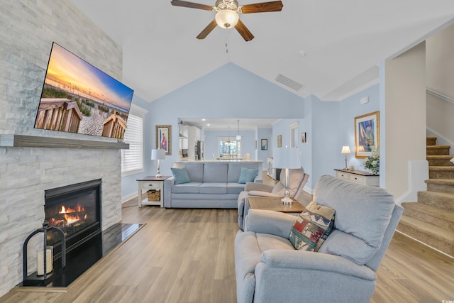 1012 Mary Read Dr, North Myrtle Beach, SC 29582 - living area with ceiling fan, stairway, vaulted ceiling, a stone fireplace, and light wood finished floors