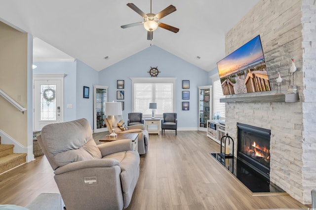 1012 Mary Read Dr, North Myrtle Beach, SC 29582 - living room featuring a stone fireplace, stairs, a ceiling fan, wood finished floors, and lofted ceiling