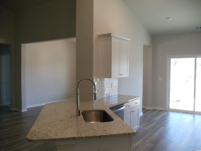 8715 Baton Rouge Ave NW, Calabash, NC 28467 - kitchen with a sink, dark wood-style floors, light stone countertops, tasteful backsplash, and white cabinetry