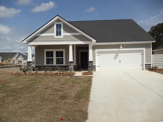 8715 Baton Rouge Ave NW, Calabash, NC 28467 - craftsman-style home with concrete driveway, a porch, a garage, a front yard, and stone siding