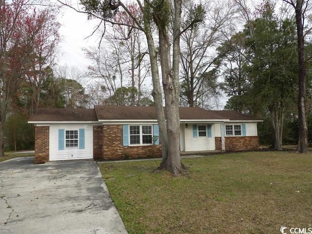ranch-style home with brick siding, driveway, and a front yard