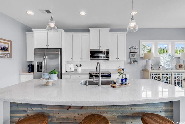 104 Splendor Cir, Murrells Inlet, SC 29576 - kitchen featuring stainless steel appliances, a sink, an island with sink, white cabinetry, and tasteful backsplash