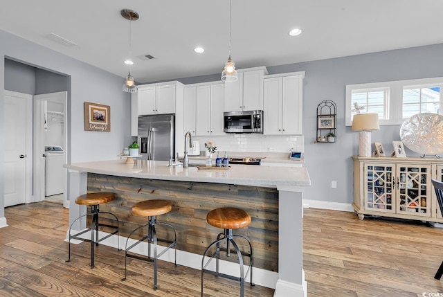 104 Splendor Cir, Murrells Inlet, SC 29576 - kitchen featuring stainless steel appliances, light wood-style floors, light countertops, tasteful backsplash, and recessed lighting