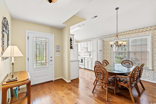 4002 Acorn Way N, Myrtle Beach, SC 29582 - dining room featuring a chandelier, light wood-style floors, wallpapered walls, and lofted ceiling