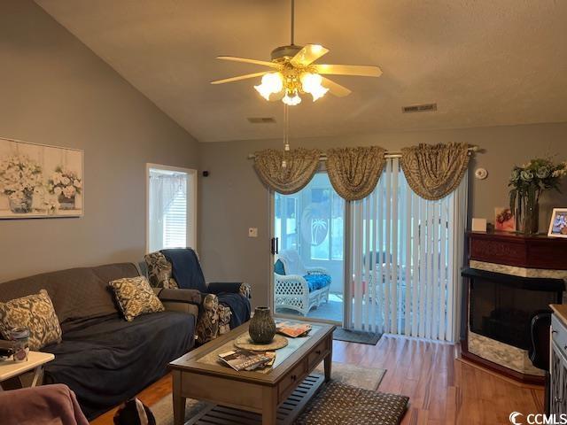 550 Bridgeport Dr, Myrtle Beach, SC 29577 - living room with ceiling fan, wood finished floors, a glass covered fireplace, and lofted ceiling