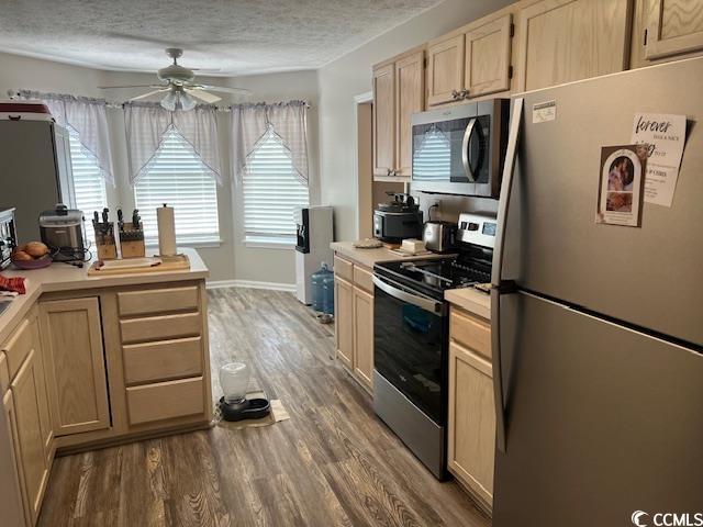 550 Bridgeport Dr, Myrtle Beach, SC 29577 - kitchen featuring stainless steel appliances, a ceiling fan, light brown cabinetry, light countertops, and light wood-style floors