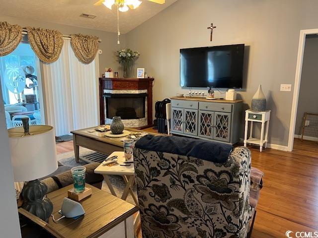 550 Bridgeport Dr, Myrtle Beach, SC 29577 - living room with ceiling fan, wood finished floors, baseboards, lofted ceiling, and a fireplace