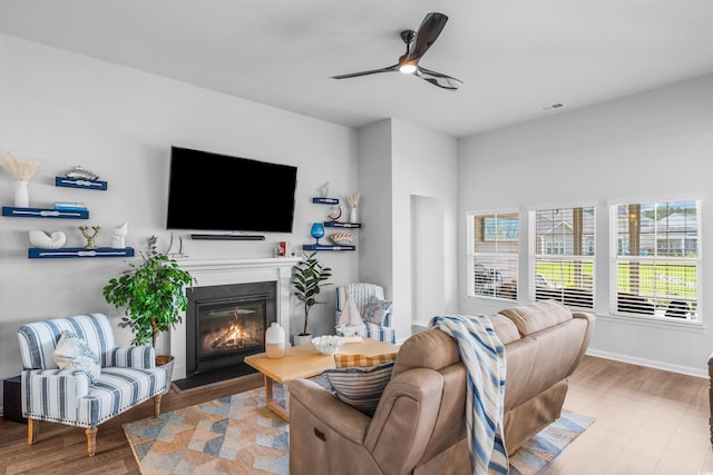 1664 White Starfish Ct, Calabash, NC 28467 - living area with wood finished floors, a glass covered fireplace, a ceiling fan, and baseboards