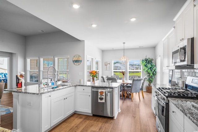 1664 White Starfish Ct, Calabash, NC 28467 - kitchen with appliances with stainless steel finishes, a sink, recessed lighting, white cabinetry, and light wood-type flooring
