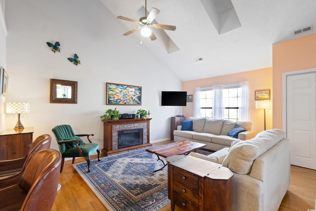 1422 Baldwin Ct Unit 1422, Little River, SC 29566 - living room featuring high vaulted ceiling, ceiling fan, light wood finished floors, a glass covered fireplace, and a skylight