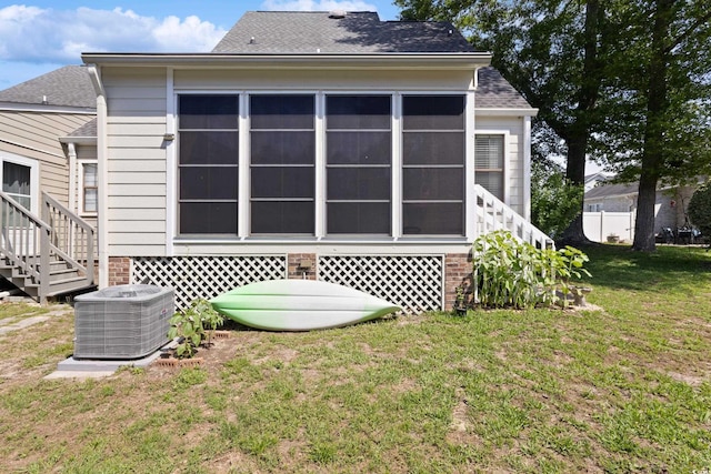 1422 Baldwin Ct Unit 1422, Little River, SC 29566 - rear view of house featuring central AC unit, a lawn, a sunroom, roof with shingles, and stairway