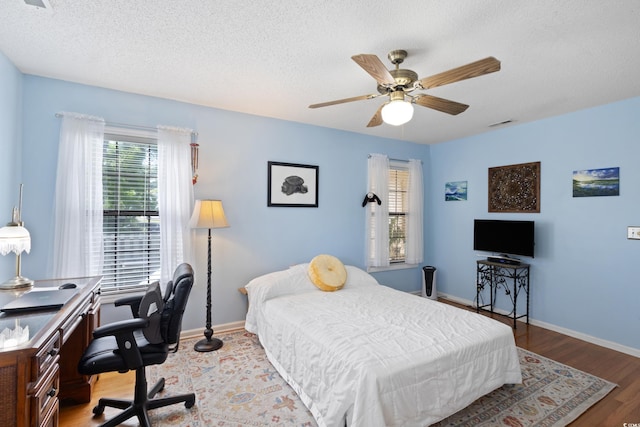 1422 Baldwin Ct Unit 1422, Little River, SC 29566 - bedroom featuring a textured ceiling, an office area, a ceiling fan, light wood-type flooring, and baseboards