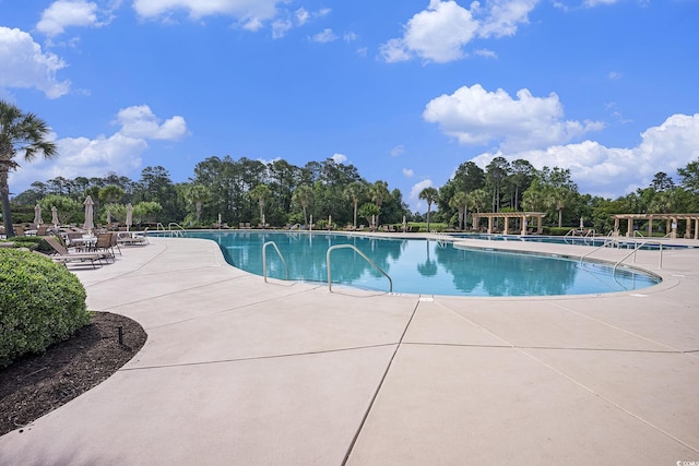 community pool with a patio and view of scattered trees