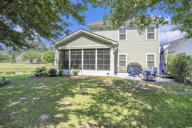 back of house featuring a fire pit, a sunroom, a lawn, and a patio
