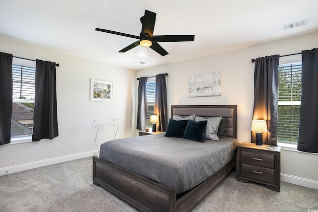 bedroom with baseboards, light colored carpet, and multiple windows