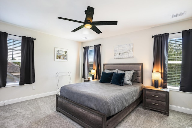 bedroom featuring baseboards, light carpet, and multiple windows