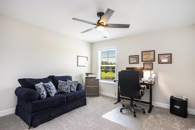 home office featuring a ceiling fan, light carpet, and baseboards