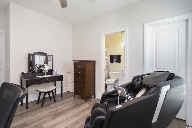 sitting room with light wood finished floors, a ceiling fan, an office area, and baseboards