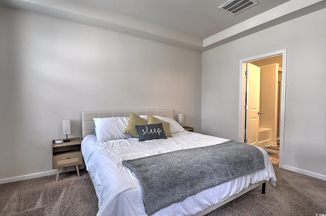 carpeted bedroom featuring baseboards and connected bathroom
