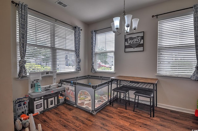 dining room with a chandelier, wood finished floors, healthy amount of natural light, and baseboards