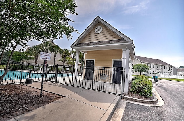 view of front facade with a community pool and a patio