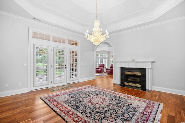 423 Chapman Loop, Pawleys Island, SC 29585 - living room featuring arched walkways, a chandelier, wood finished floors, ornamental molding, and a raised ceiling