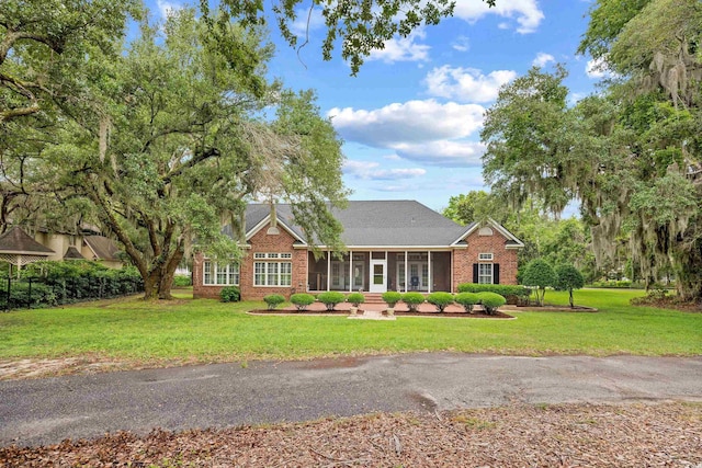 423 Chapman Loop, Pawleys Island, SC 29585 - view of front of house with a sunroom, brick siding, and a front lawn
