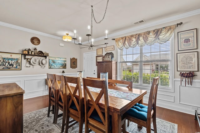 1189 Wyatt Ln, Myrtle Beach, SC 29577 - dining area featuring ornamental molding, dark wood-style flooring, a chandelier, wainscoting, and a decorative wall