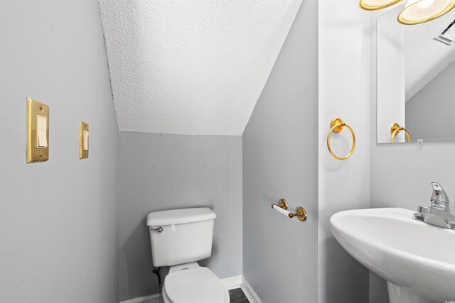 4406 Barcelona Ln, Little River, SC 29566 - bathroom with a textured ceiling, lofted ceiling, a sink, toilet, and baseboards