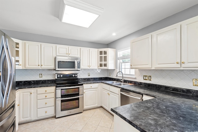 4406 Barcelona Ln, Little River, SC 29566 - kitchen with stainless steel appliances, a sink, decorative backsplash, glass insert cabinets, and light tile patterned floors