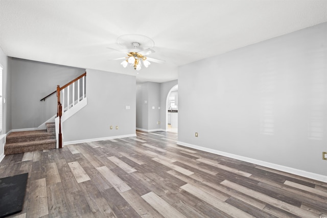 4406 Barcelona Ln, Little River, SC 29566 - unfurnished living room with wood finished floors, ceiling fan, arched walkways, stairs, and baseboards