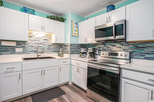 1205 King St, Myrtle Beach, SC 29577 - kitchen with stainless steel appliances, a sink, light countertops, crown molding, and wood finished floors
