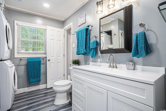 1205 King St, Myrtle Beach, SC 29577 - bathroom featuring stacked washer / dryer, toilet, wood finished floors, vanity, and baseboards