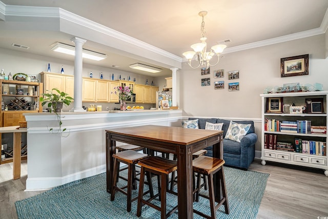 2180 Waterview Dr Unit 725, North Myrtle Beach, SC 29582 - dining area featuring decorative columns, ornamental molding, a chandelier, light wood finished floors, and wainscoting