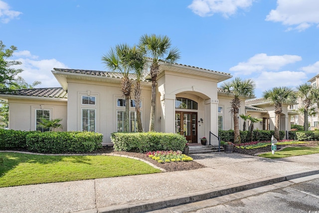 2180 Waterview Dr Unit 725, North Myrtle Beach, SC 29582 - mediterranean / spanish-style house with stucco siding, a tiled roof, french doors, and a front yard