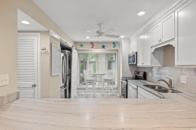 430 Ocean Creek Dr Unit 2534, Myrtle Beach, SC 29572 - kitchen featuring stainless steel appliances, a sink, ceiling fan, stacked washer and clothes dryer, and tasteful backsplash