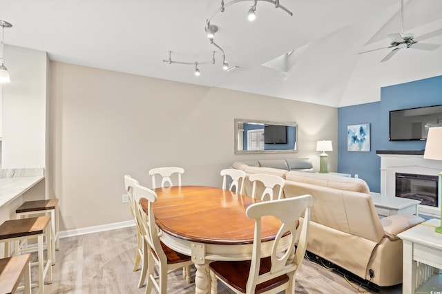 430 Ocean Creek Dr Unit 2534, Myrtle Beach, SC 29572 - dining room with light wood-style flooring, a glass covered fireplace, ceiling fan, baseboards, and a skylight