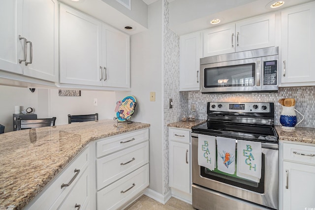 1801 N Ocean Blvd Unit Q-2, North Myrtle Beach, SC 29582 - kitchen featuring appliances with stainless steel finishes, white cabinetry, decorative backsplash, and light stone counters