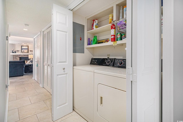 1801 N Ocean Blvd Unit Q-2, North Myrtle Beach, SC 29582 - washroom featuring washing machine and clothes dryer, electric panel, a fireplace, and light tile patterned flooring