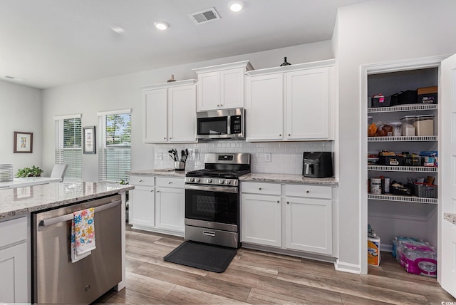 179 Empyrean Cir, Myrtle Beach, SC 29588 - kitchen with appliances with stainless steel finishes, tasteful backsplash, white cabinets, light wood-type flooring, and recessed lighting